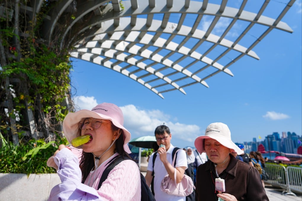 Tourists have ice cream along the Tsim Sha Tsui promenade on February 16, Hong Kong’s warmest Chinese New Year’s Eve on record. Photo: Sam Tsang
