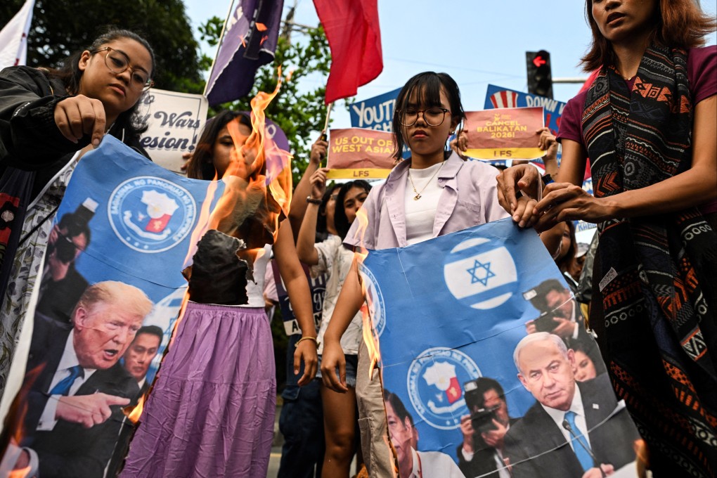 Protesters burn a banner with a picture of US President Donald Trump and Israeli Prime Minister Benjamin Netanyahu during a rally near the American embassy in Manila on Friday. Photo: Reuters