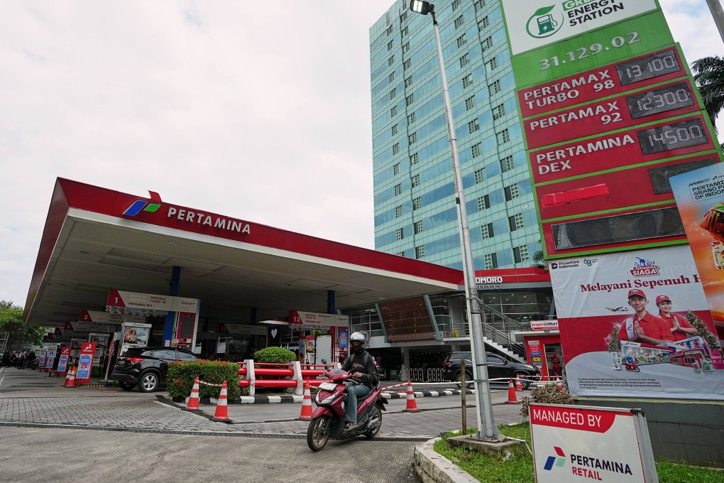 A motorist rides past a Pertamina petrol station displaying prices of fuel in  Jakarta on Tuesday. Photo: AP