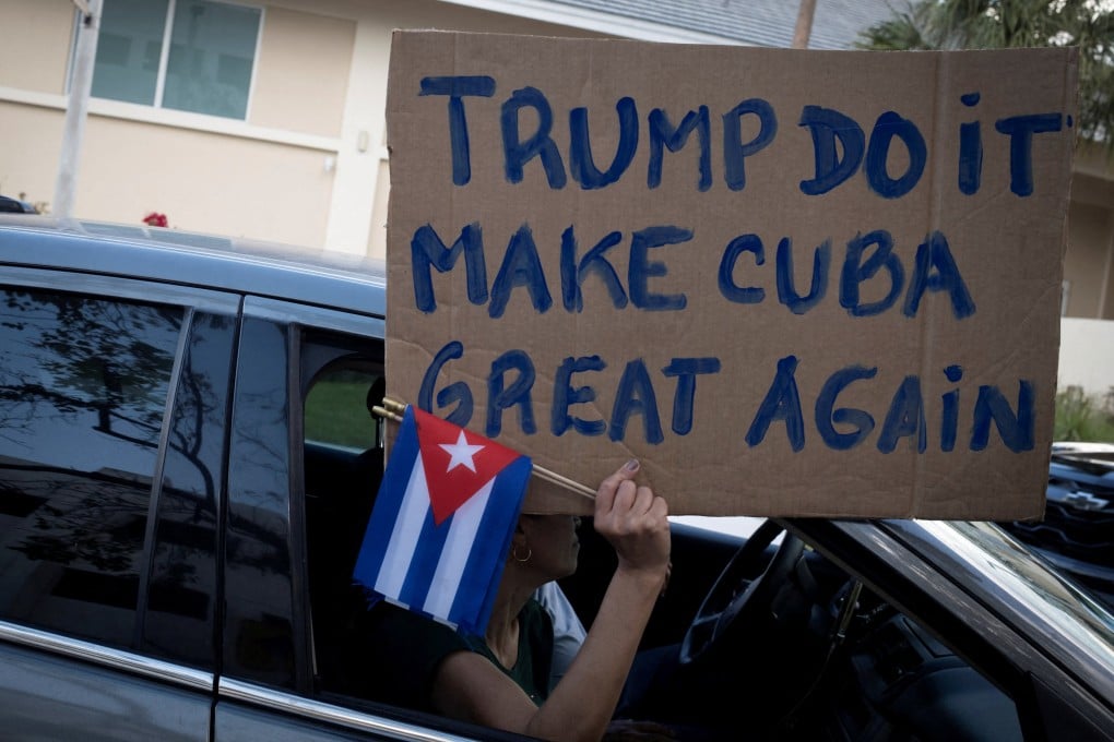 A woman holds a pro-Trump sign and Cuban flags during a protest against Cuba’s government in Miami, Florida, in February. Photo: Reuters