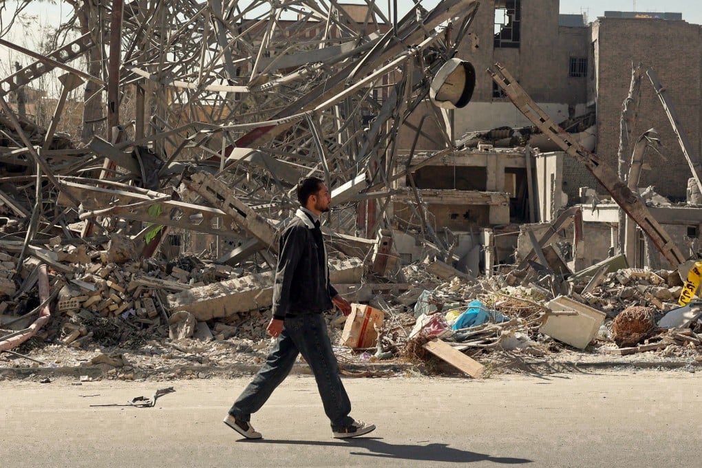 A man in Tehran walks past the aftermath of airstrikes on the city. Photo: AFP