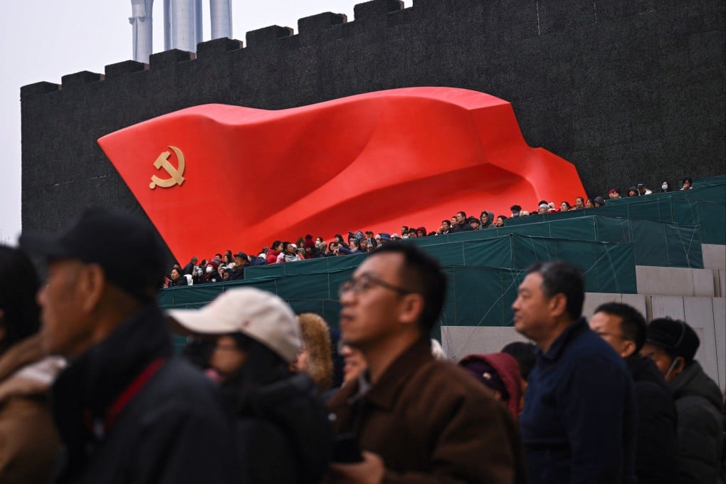 People watch a Chinese New Year performance of traditional Chinese dances with a sculptural flag of the Communist Party seen in the background, in Beijing on March 1. Photo: AFP