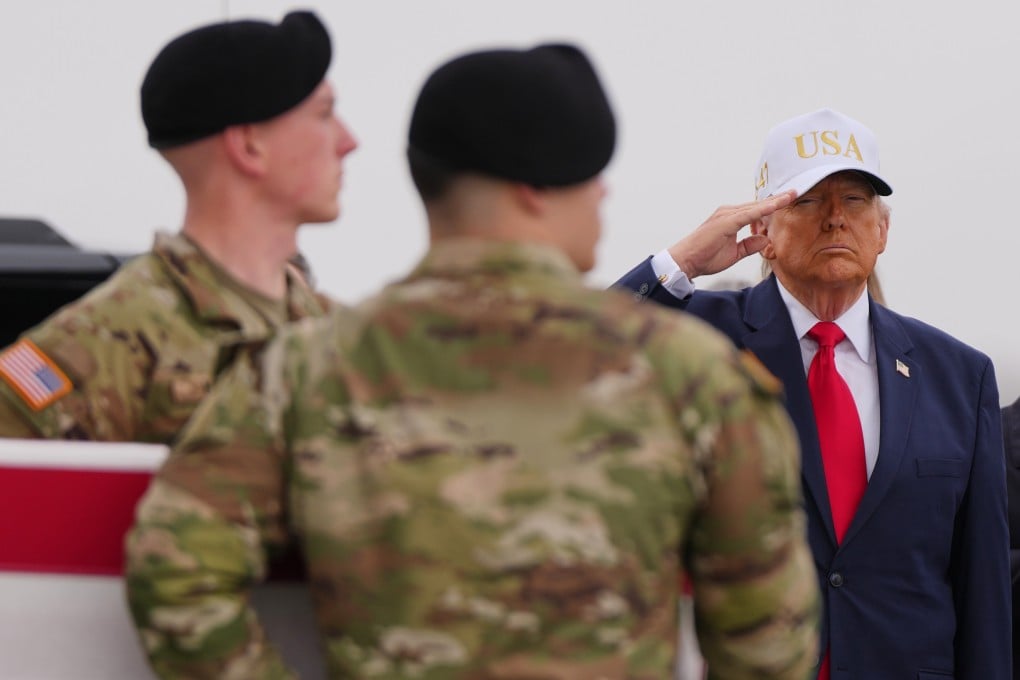 US President Donald Trump salutes at Dover Air Force Base in Delaware on Saturday as an Army carry team moves the flag-draped transfer case containing the remains of one of the US soldiers killed in Kuwait. Photo: AP