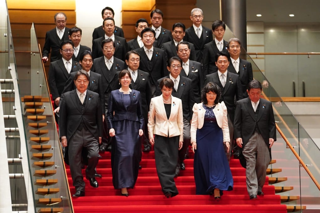 Japan’s Prime Minister Sanae Takaichi (centre, front) walks down the stairs to pose for a photo session with members of her cabinet in Tokyo on February 18. Photo: EPA