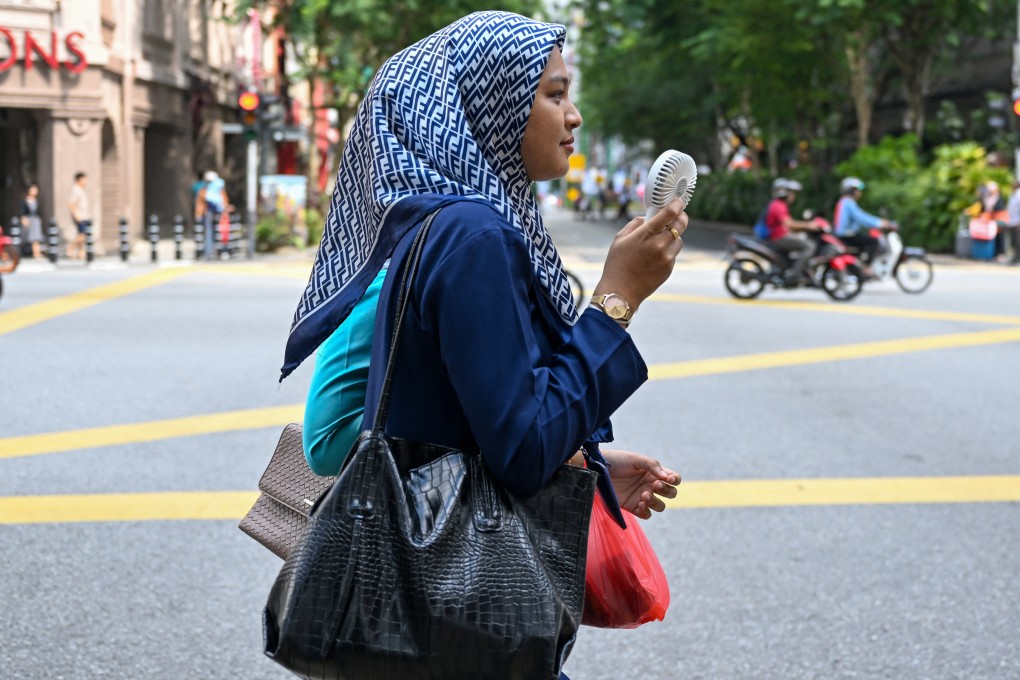 A women uses an electric fan to cool off in Kuala Lumpur, Malaysia, in May 2023. Photo: AFP