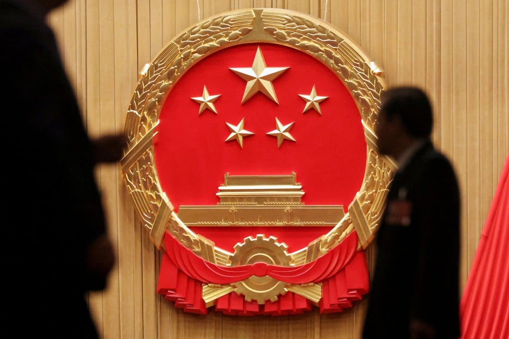 Delegates walk past China’s national emblem at the Great Hall of the People in Beijing before the national legislature’s second plenary session in Beijing on Monday. Photo: Reuters
