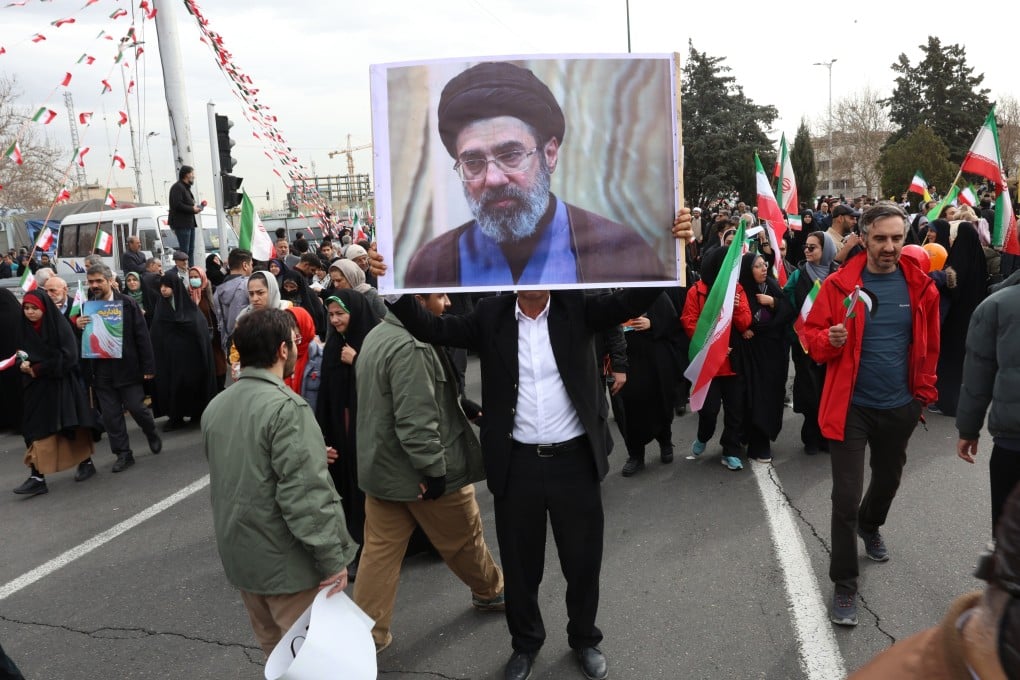 An Iranian man holds a picture of Mojtaba Khamenei, the son of the Iranian supreme leader, in Tehran, Iran on February 11. Photo: EPA