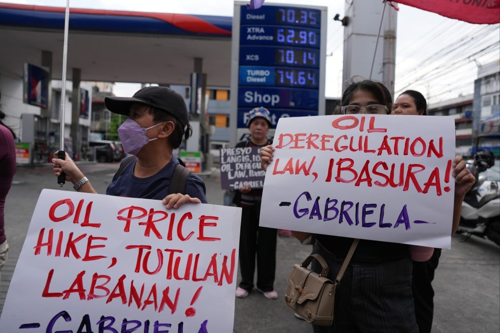 Protesters hold slogans that read “Junk the oil deregulation law” during a rally against the recent big oil price increase on Tuesday outside a petrol station in Quezon City, the Philippines. Photo: AP
