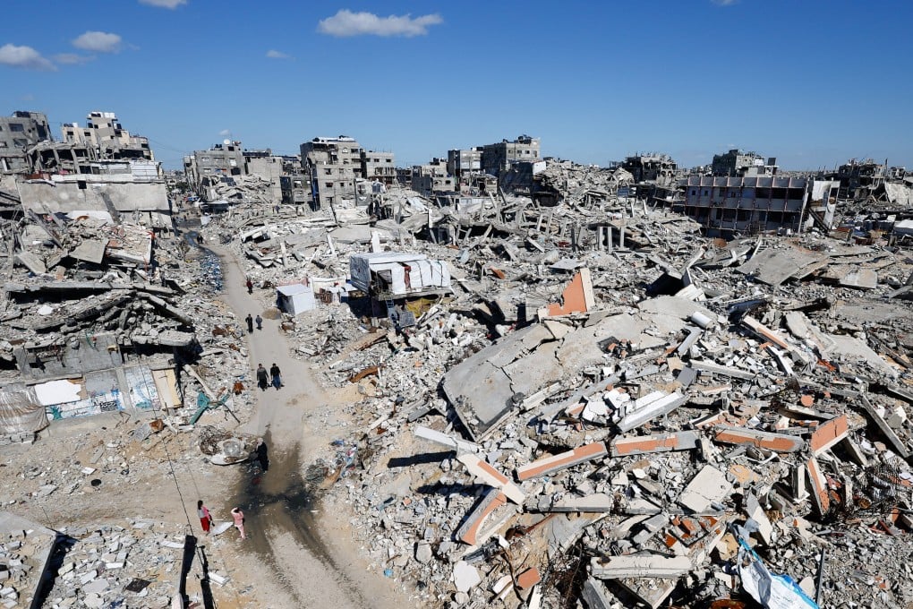 Palestinians walk past the rubble of residential buildings destroyed during the two-year Israeli offensive, in Jabalia, northern Gaza Strip. Photo: Reuters