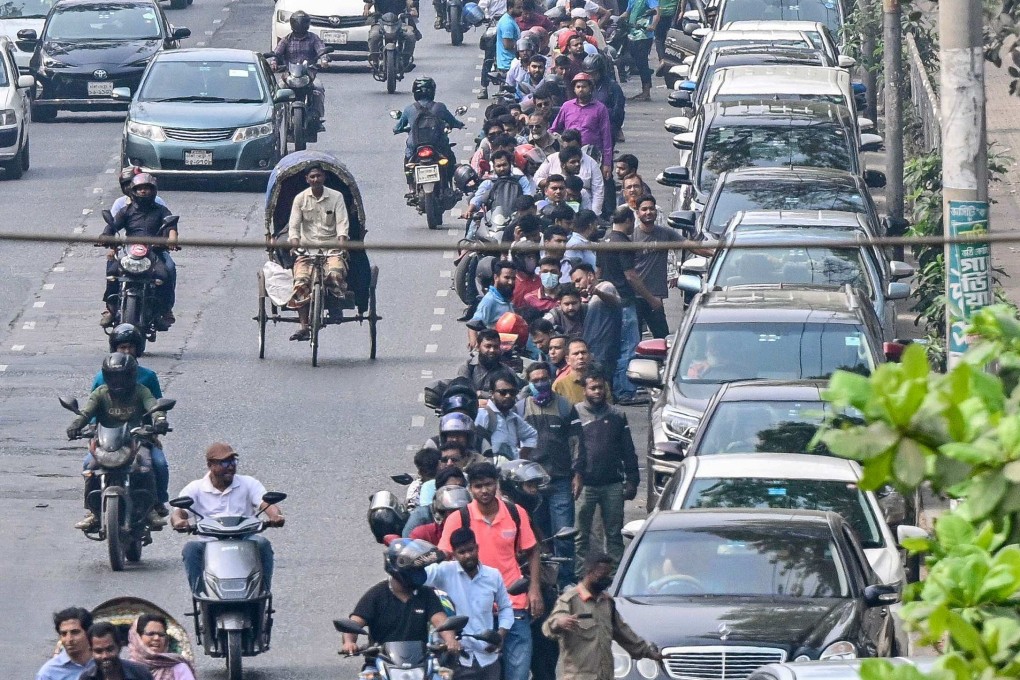 People wait to refuel their vehicles near a fuel station in Dhaka on Monday. Bangladesh launched fuel rationing on Sunday. Photo: AFP