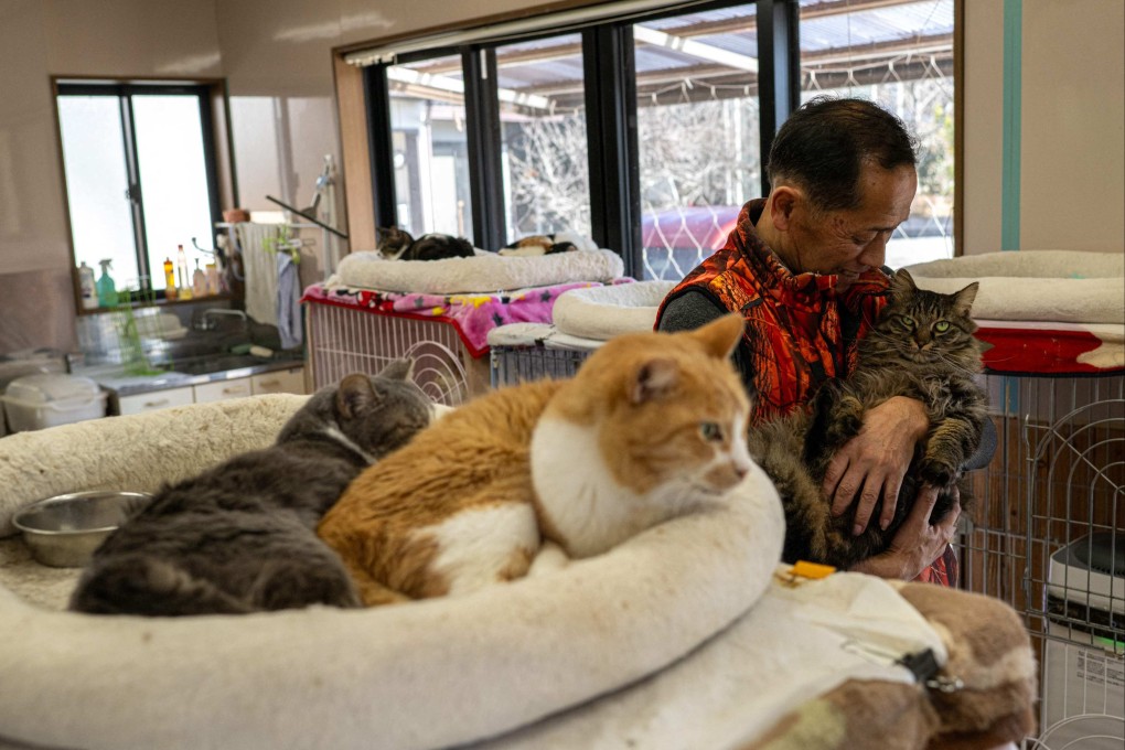 Former nuclear plant worker Toru Akama cuddles a cat at his animal shelter in Fukushima prefecture. Photo: AFP