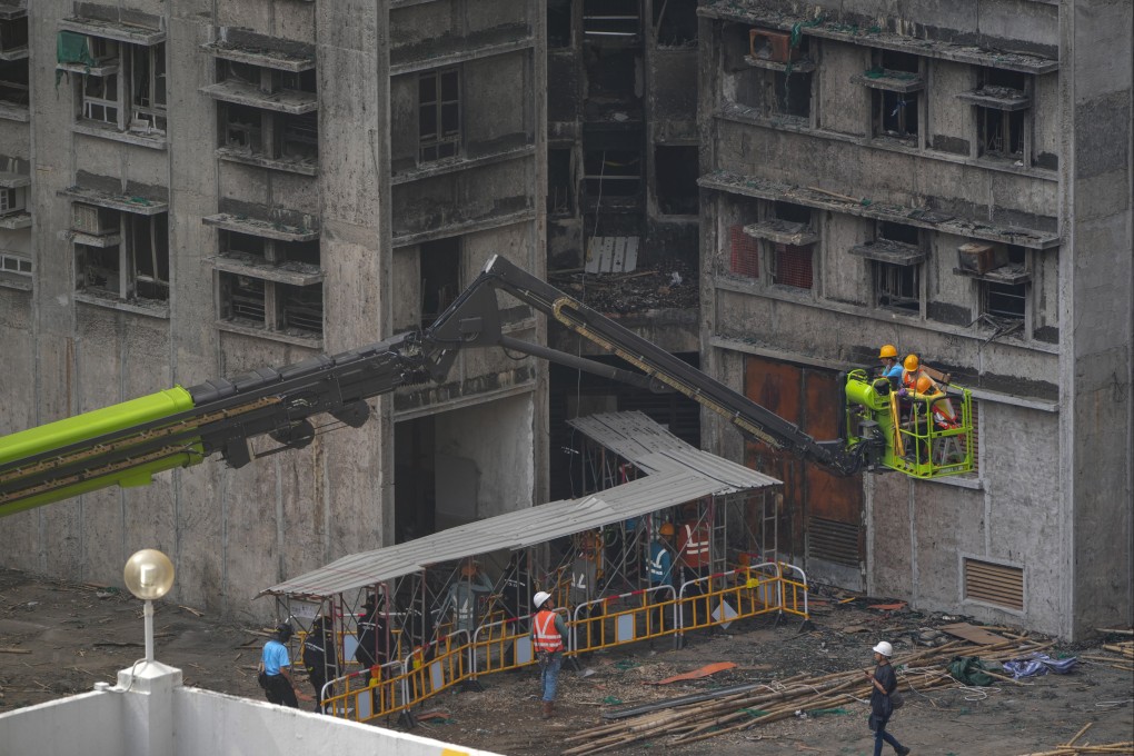 Construction workers enter one of the buildings of Wang Fuk Court in Tai Po, along with police officers, for structural reinforcement work on March 9. Photo: Sam Tsang
