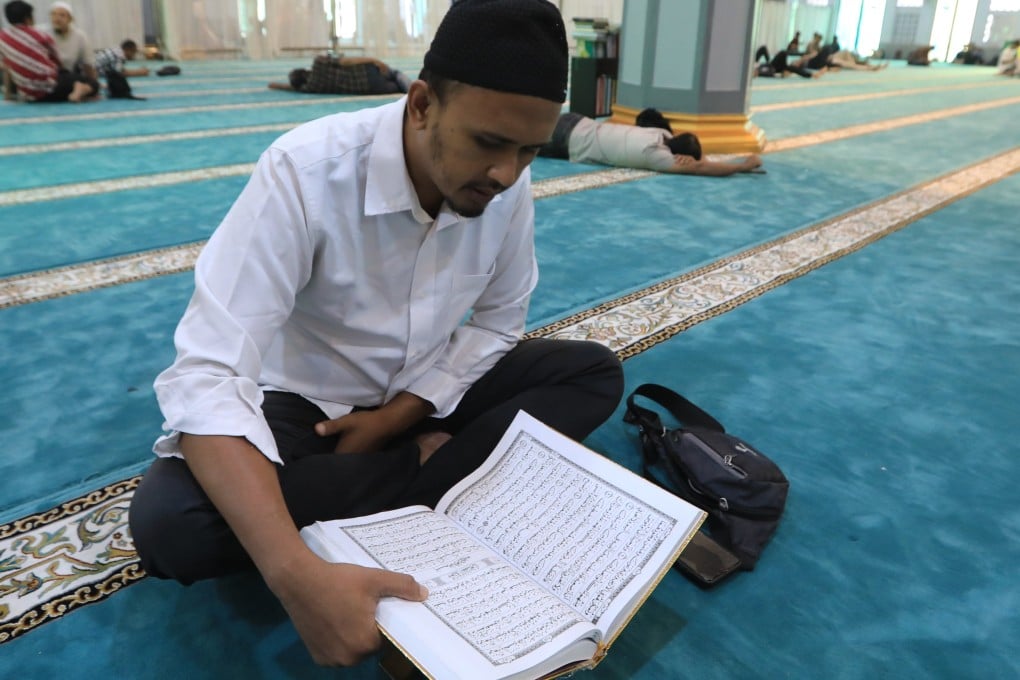 A Muslim man reads the Quran while waiting to break fast during the holy month of Ramadan in Banda Aceh, Indonesia, on Thursday. Photo: EPA