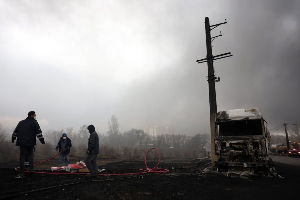 Iranians work as smoke rises from an oil refinery struck in Tehran, on March 8, amid joint Israeli-US attacks. Photo: EPA