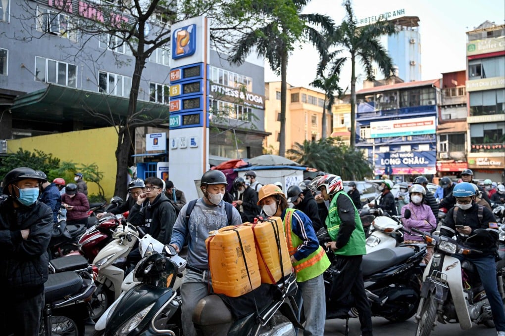 Motorists, some with containers, queue for gasoline at a gas station in Hanoi on March 10. Photo: AFP