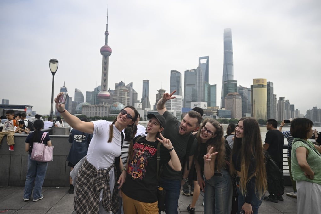 Overseas visitors pose for selfies in Shanghai’s Bund area. Photo: Xinhua