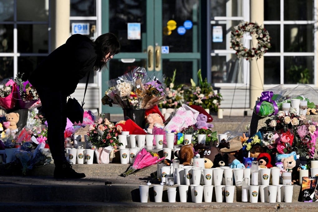 A woman visits a makeshift memorial to shooting victims in Tumbler Ridge, British Columbia, Canada, in February. Photo: Reuters