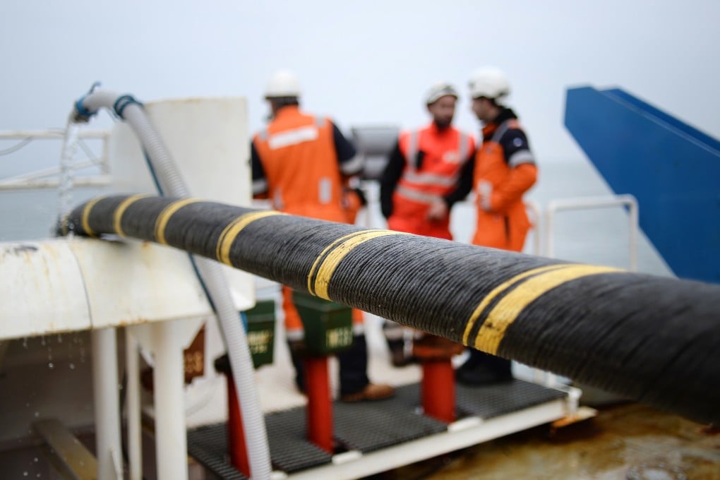 Workers install a submarine communications cable in western France. Photo: AFP