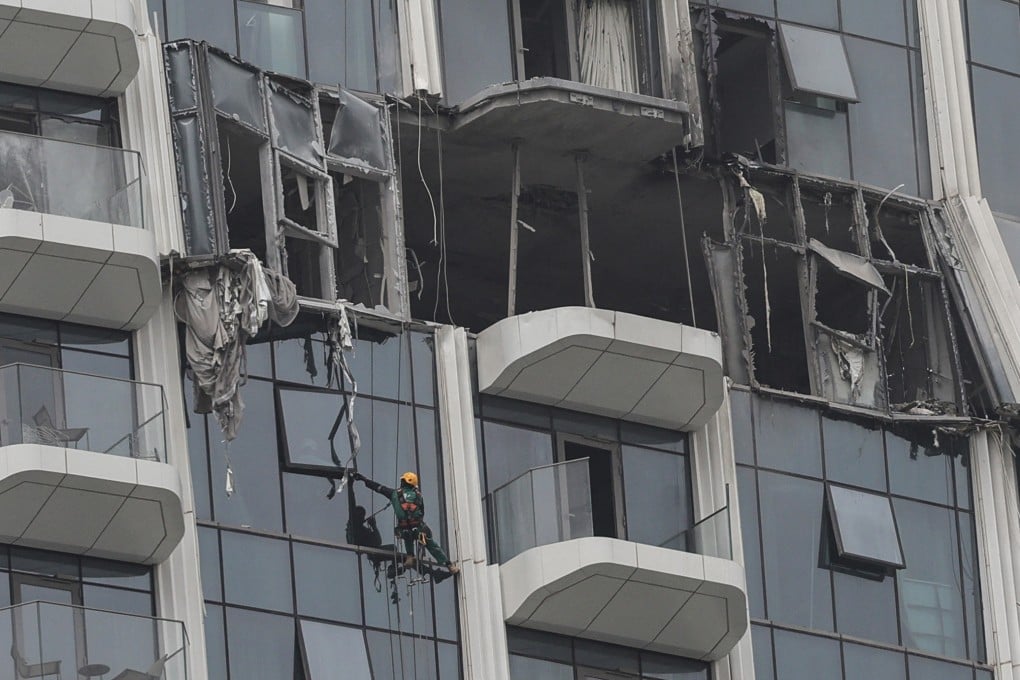 A worker assesses the damage after a drone strike on a building in Dubai’s Creek Harbour neighbourhood on Thursday. Photo: Getty Images/AFP