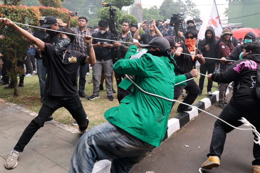 Indonesian students and activists try to tear down a gate in front of the parliament building in Jakarta during a protest against the revision of the country’s military law  on March 20, 2025. Photo: EPA-EFE