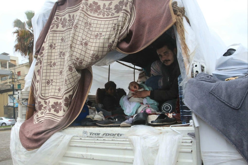 A displaced Lebanese family sit in the back of a truck, their current home, in the southern city of Sidon on Sunday. Photo: AFP