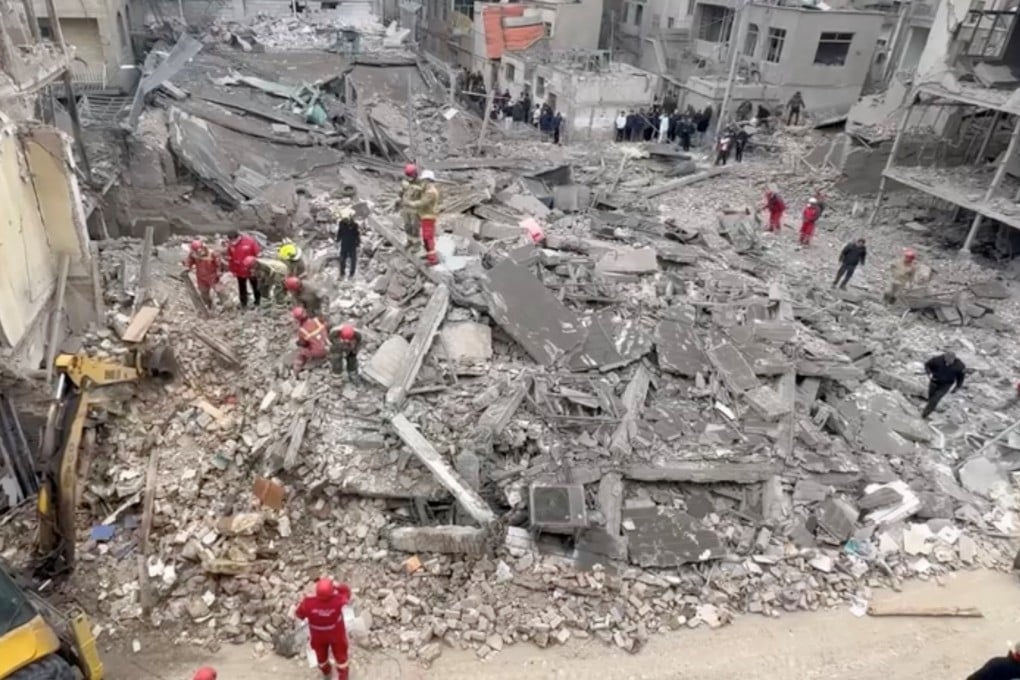 Iranian Red Crescent aid workers and firefighters work at a residential site damaged by strikes in Tehran’s Javadiyeh district on Saturday. Photo: Iranian Red Crescent Society via Reuters