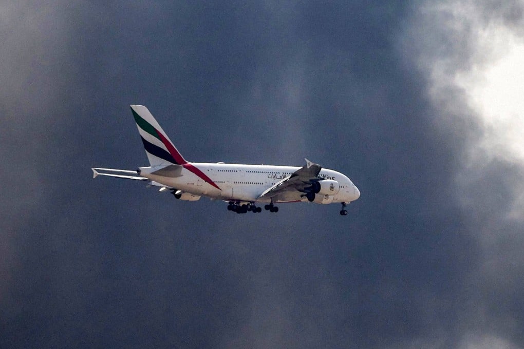 An Emirates Airbus A380 aircraft prepares to land as a smoke plume rises from an ongoing fire near Dubai International Airport in Dubai on Mpnday. Photo: AFP