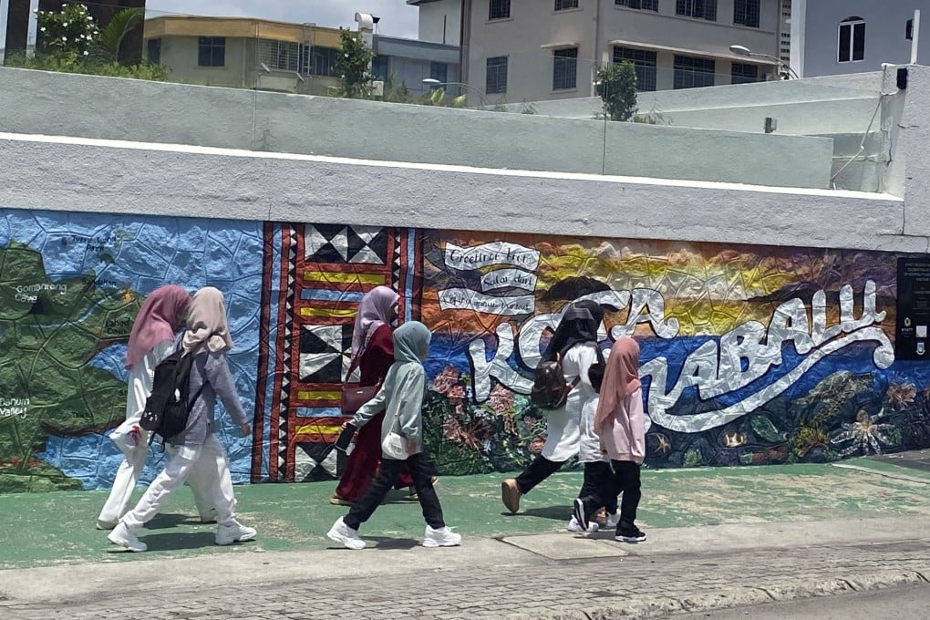 People walk past a mural in Kota Kinabalu, Sabah. Photo: Tamara Hinson
