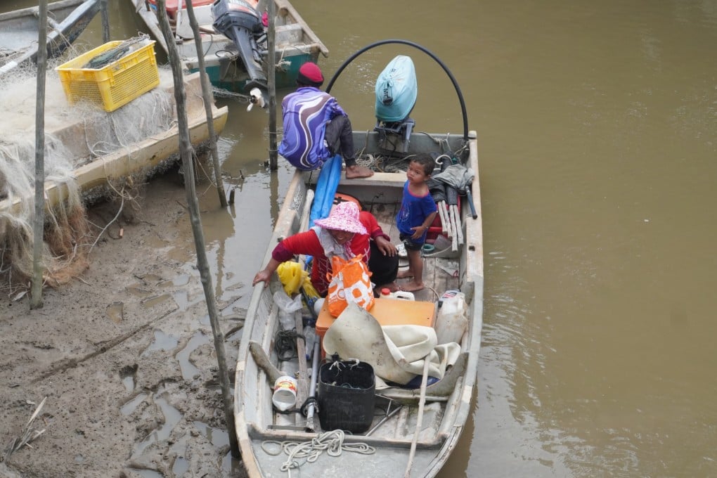 Malaysian fisherman Lingan bin Man pulls up to the jetty in Kampung Sungai Kurau with his family. Photo: Ushar Daniele