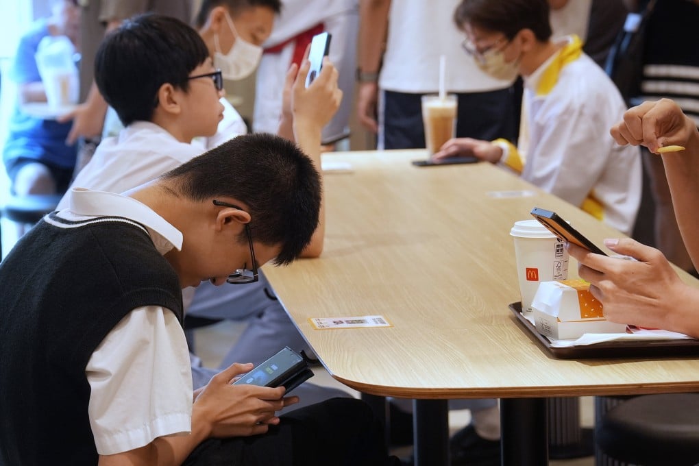 Secondary school students on their smartphones while having meal. Photo: Elson Li