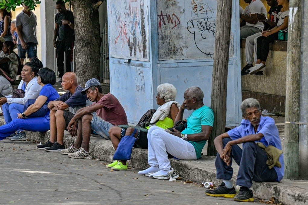 People wait at a bus stop in Havana, Cuba during a blackout on Monday. Photo: AFP