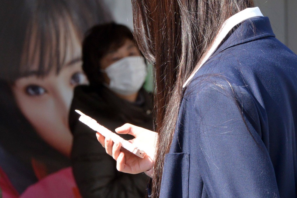 A high school girl uses her smartphone in Tokyo, Japan. Photo: AFP