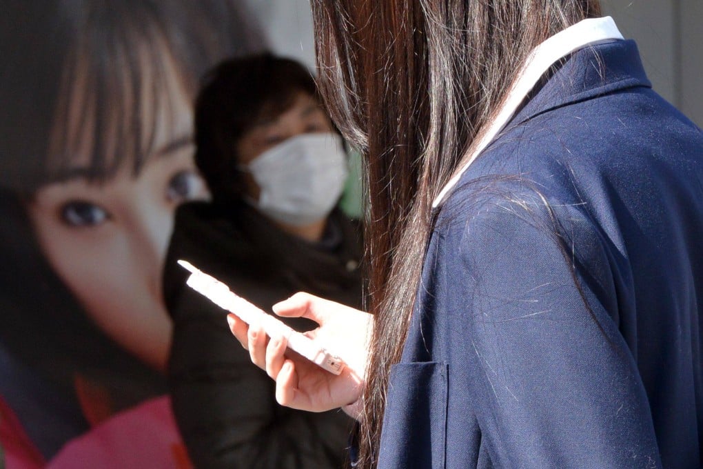 A high school girl uses her smartphone in Tokyo, Japan. Photo: AFP