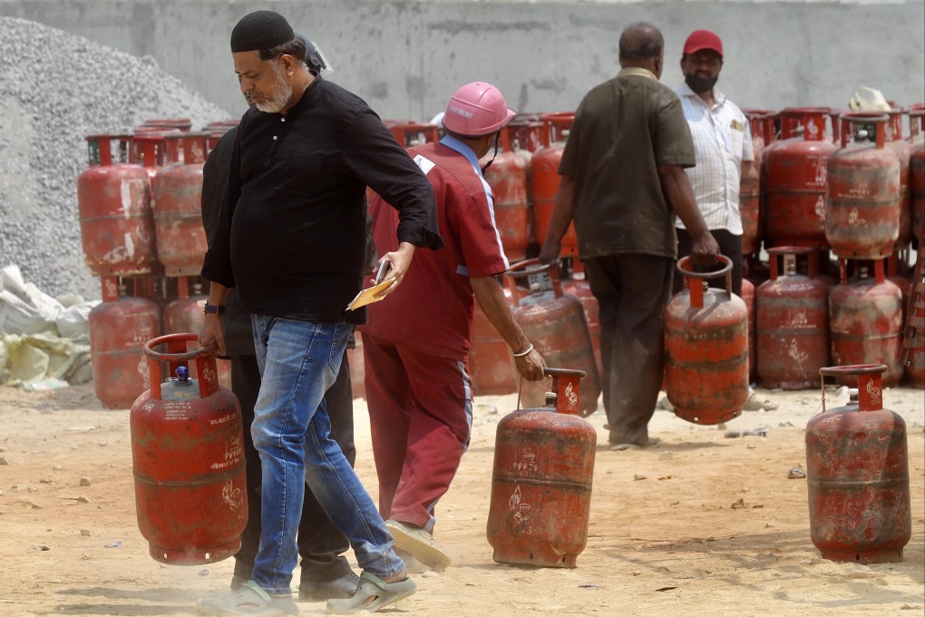 Customers carry empty LPG cylinders to exchange for refilled ones at a gas agency office in Bengaluru, India, on Monday. Photo: EPA