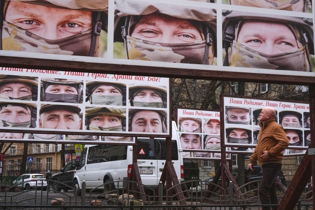 A man walks past portraits of Russian soldiers in a St Petersburg street exhibition. Photo: AP