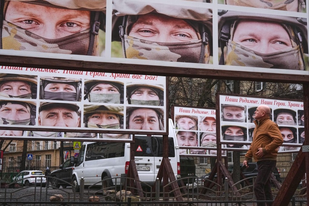 A man walks past portraits of Russian soldiers in a St Petersburg street exhibition. Photo: AP