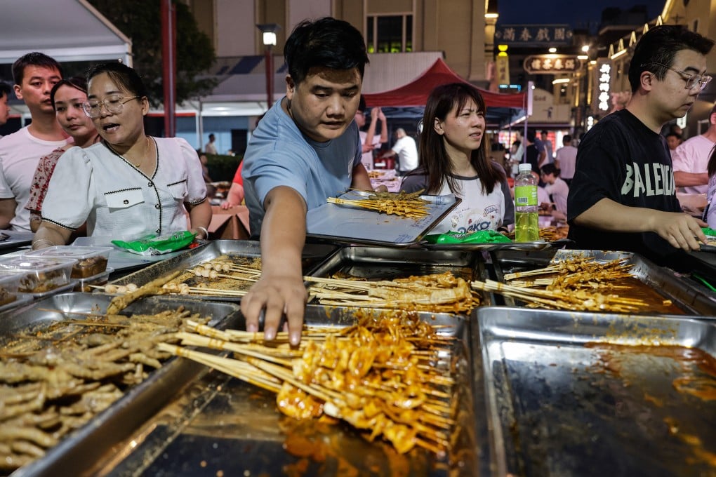 People go for skewers during a Zibo barbecue festival in Wuhan, Hubei province in 2023. As Chinese food reinvents itself overseas, different food cultures are coming to the surface of the uniform concrete-and-glass facades of Chinese cities. Photo: Getty Images