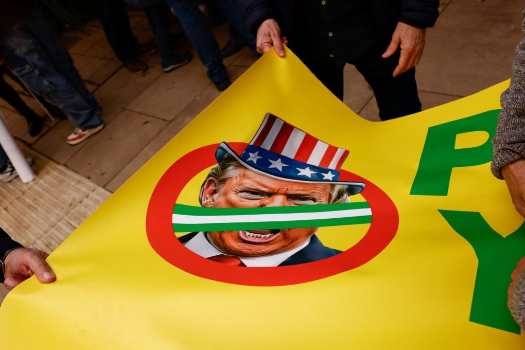 People hold a banner with an image of US President Donald Trump during an anti-war protest in Malaga, Spain, on March 7. Photo: Reuters