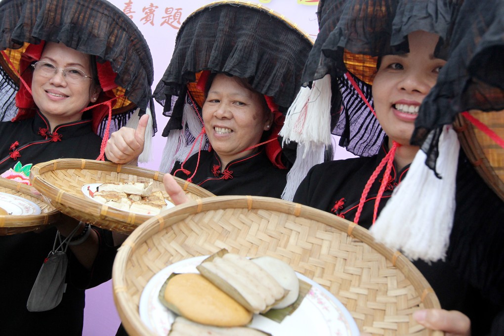 Hakka women dressed in traditional costumes hold trays of Hakka foods during the opening ceremony of the Hakkien Food Carnival at Tai Po Lam Tsuen, Hong Kong, in July 2013. Photo: SCMP