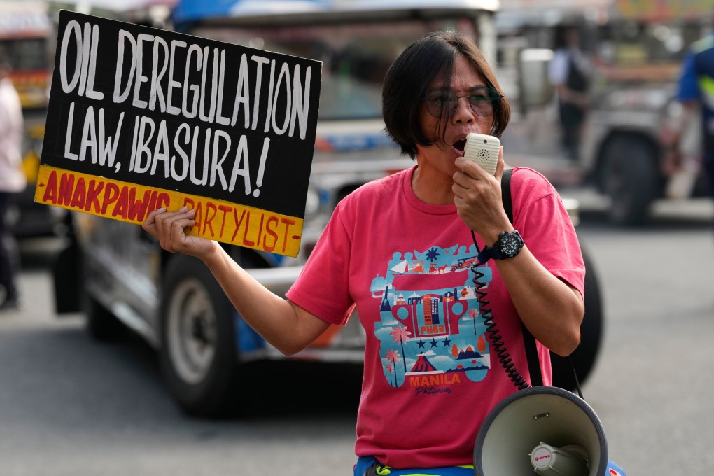 A protester holds a slogan that reads “scrap the oil deregulation law” as  jeepney drivers hold a transport strike in Quezon City on Thursday. Photo: AP