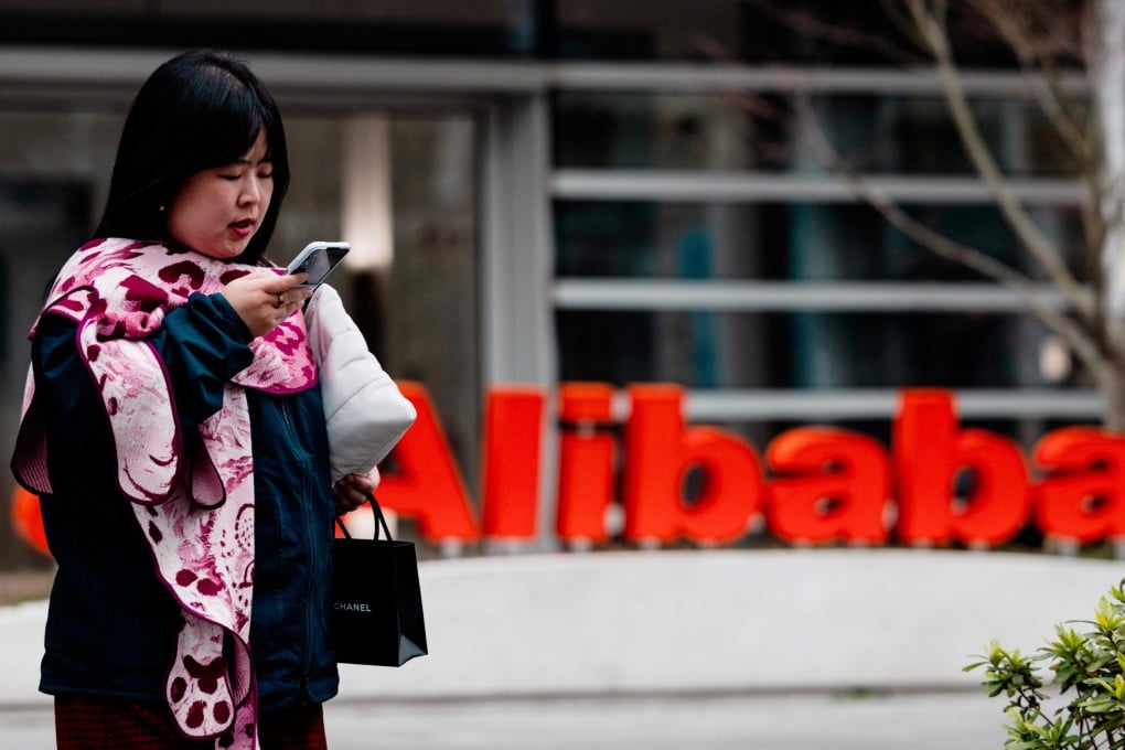 A woman walks past the Alibaba logo on its building in Xuhui Binjiang Park, also known as AI Park, in Shanghai, on March 19, 2026.  Photo: EPA