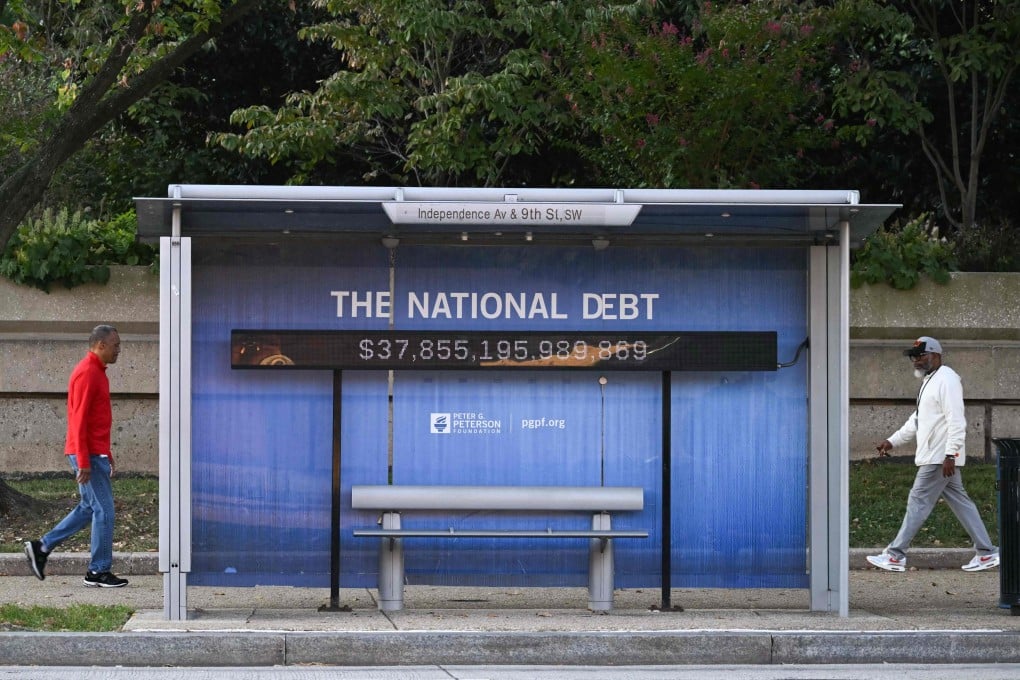 People walk past a bus stand displaying the US national debt in Washington, DC on October 7, 2025. Photo: AFP