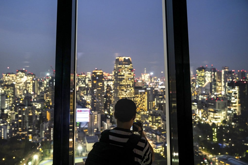 A visitor takes photos of Tokyo’s skyline. File photo: AP