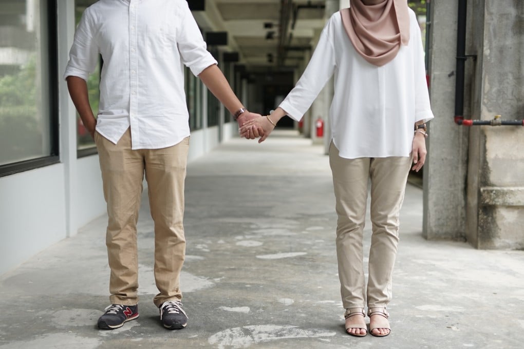 A Malaysian couple hold hands. A new study has found that 60 per cent of respondents from Malaysia agreed with the statement that “a wife should always obey her husband”. Photo: Shutterstock