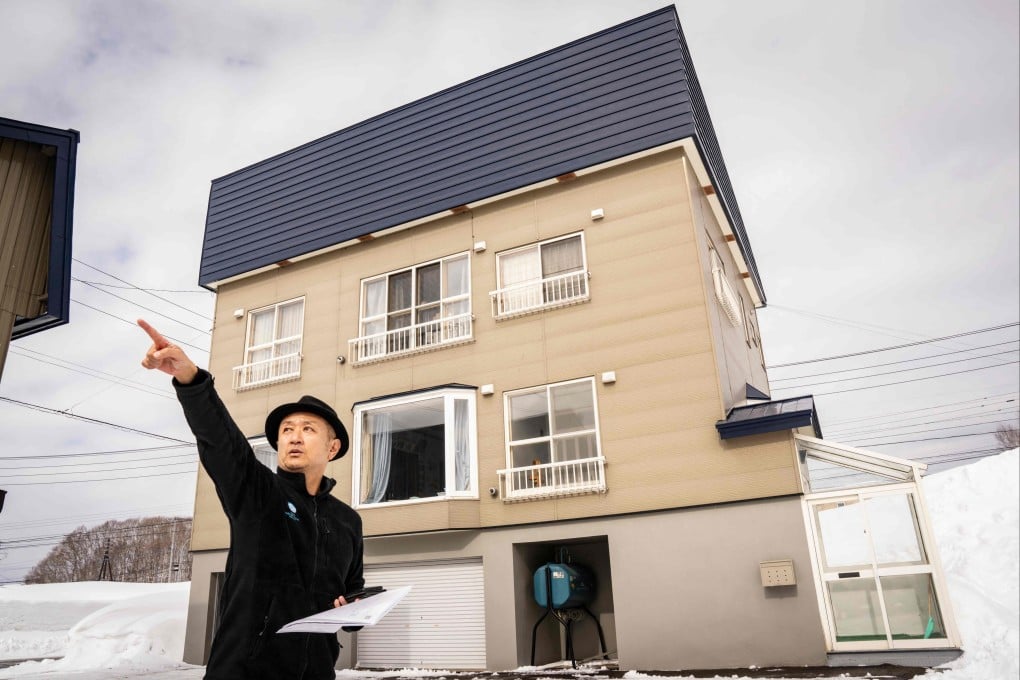 A real estate agent points to the view from a property in Niseko, Japan, on February 20. Photo: AFP