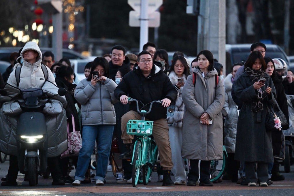 People wait to cross a road in Beijing on March 6. A private-credit crisis could prompt a wave of restructuring of loans due to China, complicating its efforts to counter a structural downturn. Photo: AFP