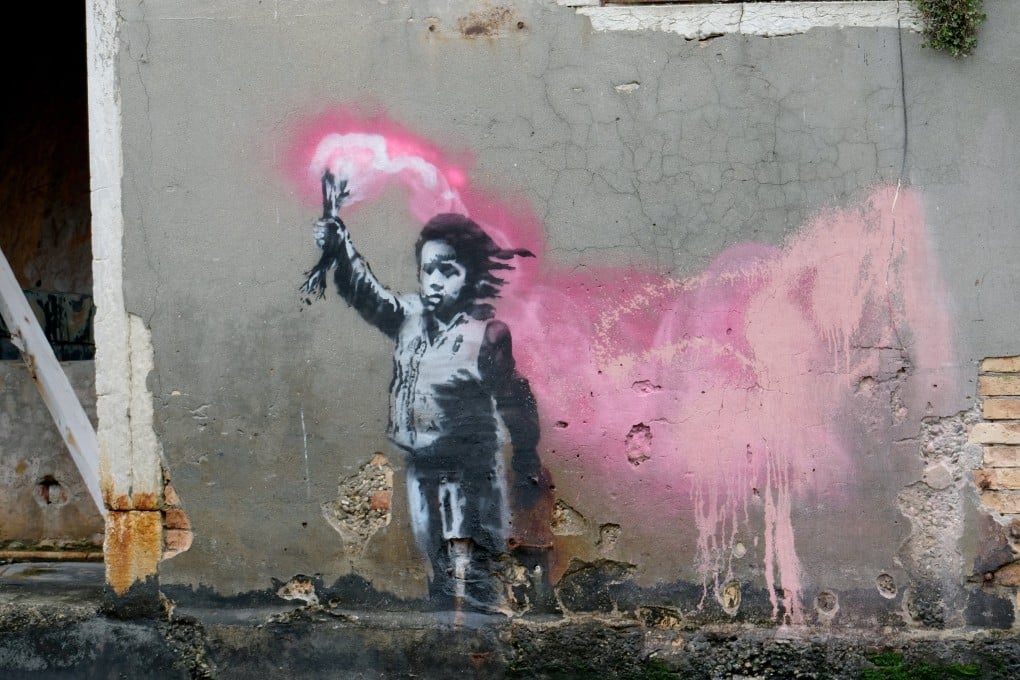 A suspected Banksy piece seen in Venice, Italy, in 2019, depicting a migrant child holding a pink flare. Fans of the guerilla street artist have mourned the apparent revelation of his identity, but art experts say his true magic is in his message rather than his anonymity. Photo: Reuters