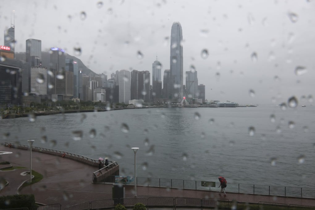 People brave the rain at Wan Chai promenade while a black rainstorm warning is issued by the Hong Kong Observatory on August 14, 2025. Photo: Nora Tam