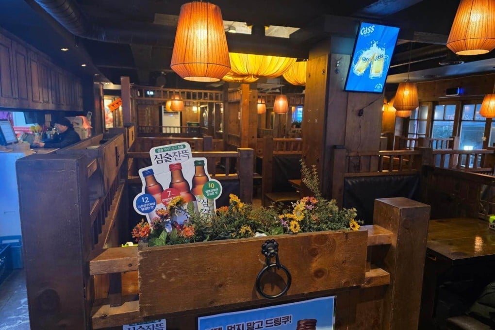 Empty tables are seen behind alcohol promotional displays at a bar near Seoul National University in South Korea. Photo: Korea Times