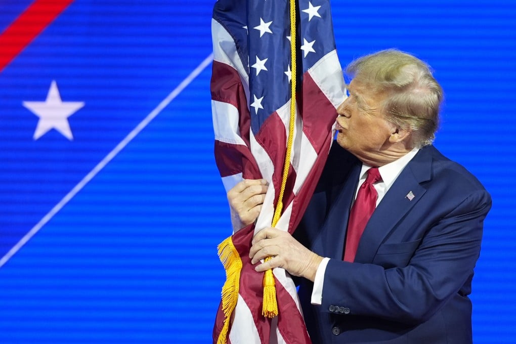 Donald Trump hugs and kisses the American flag at CPAC 2024. Photo: AP